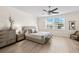 Neutral bedroom with a ceiling fan, light wood floors, large window, and minimalist decor at 3702 W Cass St # 5, Tampa, FL 33609