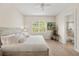 Sunlit bedroom with large arched window, ceiling fan, and en-suite bathroom at 3702 W Cass St # 5, Tampa, FL 33609