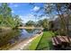 Expansive backyard featuring a tranquil pond, verdant lawn, and screened-in porch for relaxed outdoor living at 3923 Shoreside Cir, Tampa, FL 33624