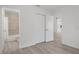 View of the bedroom with a closet and wood-look floors, with a view to the bathroom and the kitchen at 3923 Shoreside Cir, Tampa, FL 33624