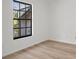 Bright bedroom with wood-look floors and a window providing natural light and views of the lush greenery outside at 3923 Shoreside Cir, Tampa, FL 33624