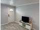 Cozy living room featuring modern flooring and a stylish entertainment center against a soothing neutral wall at 4103 Gulf Blvd # 104, St Pete Beach, FL 33706
