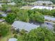 Birds-eye of building overlooking parking lot and mature trees with retail in background at 4215 E Bay Dr # 1005D, Clearwater, FL 33764