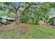 Spacious backyard featuring lush landscaping, mature trees, and a well-maintained lawn at 4215 E Bay Dr # 1005D, Clearwater, FL 33764