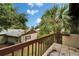 Balcony features a wooden railing with a view of a home and a palm tree at 4215 E Bay Dr # 1005D, Clearwater, FL 33764