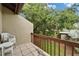 Balcony with tiled floor and wooden railing overlooks a well-maintained garden and lush trees at 4215 E Bay Dr # 1005D, Clearwater, FL 33764