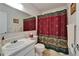 Bathroom features a sink, toilet, and shower with decorative shower curtain at 4215 E Bay Dr # 1005D, Clearwater, FL 33764