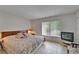 Cozy bedroom featuring a queen-size bed, natural light, and tile flooring at 4215 E Bay Dr # 1005D, Clearwater, FL 33764