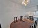 Cozy dining area with a round wooden table, chandelier lighting, and view from the window at 4215 E Bay Dr # 1005D, Clearwater, FL 33764
