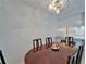 A dining room featuring a dark wood table with seating for six, set under a classic light fixture, adjacent to the kitchen at 4215 E Bay Dr # 1005D, Clearwater, FL 33764
