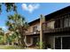 Two-story condo building with private balconies and a mature palm tree at 4215 E Bay Dr # 1005D, Clearwater, FL 33764