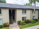 Condo exterior showcases beige stucco, second-floor access, and tidy landscaping at 4215 E Bay Dr # 1005D, Clearwater, FL 33764