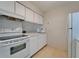 Well-lit kitchen featuring white cabinetry, modern appliances, and neutral tile flooring for a clean, functional cooking area at 4215 E Bay Dr # 1005D, Clearwater, FL 33764