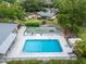 Aerial view of a community pool, shuffleboard courts, lounge chairs, and lush landscaping at 4215 E Bay Dr # 1005D, Clearwater, FL 33764