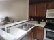 Spacious kitchen featuring stainless steel sink, plenty of counter space, and wooden cabinetry at 4537 Kennewick Pl # 4537, Riverview, FL 33578