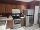 Well-lit kitchen with stainless steel appliances, sleek countertops and wooden cabinets at 4537 Kennewick Pl # 4537, Riverview, FL 33578
