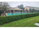 Community pool area with a covered lounge, lush landscaping, and black fencing at 4537 Kennewick Pl # 4537, Riverview, FL 33578