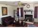 Cozy living room with a brick fireplace and mantel, complemented by a ceiling fan and warm lighting at 4819 21St S Ave, St Petersburg, FL 33711