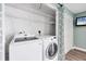 Convenient laundry room with white washer, dryer, and shelving at 4904 38Th S Way # 514, St Petersburg, FL 33711