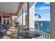 Outdoor patio with seating, overlooking the water with palms trees and an American flag at 5260 Coquina Key Se Dr # C, St Petersburg, FL 33705