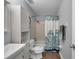 Bright bathroom with a sink, toilet, shower with curtain, and storage cabinet at 5260 Coquina Key Se Dr # C, St Petersburg, FL 33705