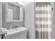 Neutral toned bathroom featuring a sink, mirror, and shower with striped curtain at 5260 Coquina Key Se Dr # C, St Petersburg, FL 33705