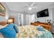 Bedroom boasts a leafy bedspread, adjoining bathroom and mounted television at 5260 Coquina Key Se Dr # C, St Petersburg, FL 33705
