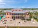 Aerial view of the clubhouse with a large patio, palm trees, and tropical flowers at 5260 Coquina Key Se Dr # C, St Petersburg, FL 33705