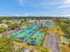 Aerial view of community courts, tennis, pickleball, and shuffleboard, with ponds and tropical foliage at 5260 Coquina Key Se Dr # C, St Petersburg, FL 33705