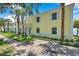Charming yellow condo building with white trim, surrounded by lush landscaping and palm trees at 5260 Coquina Key Se Dr # C, St Petersburg, FL 33705