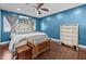 Bedroom features blue walls, wood floors, ceiling fan, and white furniture set at 5401 3Rd N Ave, St Petersburg, FL 33710