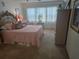 Comfortable main bedroom featuring a classic headboard, pink bedding, and bright window at 5705 80Th N St # 303, St Petersburg, FL 33709