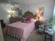 Charming main bedroom with classic furniture, pink comforter, and bright natural light at 5705 80Th N St # 303, St Petersburg, FL 33709