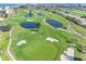 Picturesque aerial shot of the community golf course with various water features, bunkers, manicured green, and tropical trees at 6158 Palma Del Mar S Blvd # 306, St Petersburg, FL 33715