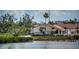 Waterfront exterior view showcasing houses with tile roofs and lush greenery at 6158 Palma Del Mar S Blvd # 306, St Petersburg, FL 33715