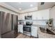 Modern kitchen featuring stainless steel appliances, granite counters, and white cabinetry at 6158 Palma Del Mar S Blvd # 306, St Petersburg, FL 33715