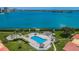 Inviting pool area with tiki huts, lounge chairs, manicured landscaping, and water views at 6158 Palma Del Mar S Blvd # 306, St Petersburg, FL 33715