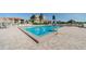 Inviting community pool area surrounded by lush landscaping, palm trees and comfortable lounge chairs with nearby condos at 6158 Palma Del Mar S Blvd # 306, St Petersburg, FL 33715