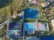 Aerial view of community pool and tennis courts surrounded by residential homes and lush landscaping at 618 Bird Bay S Dr # 111, Venice, FL 34285