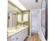 Bathroom featuring a marble countertop vanity and an adjacent shower room in a well-lit space at 618 Bird Bay S Dr # 111, Venice, FL 34285