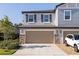 Close-up of a two-story townhome featuring a two-car garage with stone accents and well-kept landscaping at 6542 95Th N Pl, Pinellas Park, FL 33782