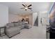 Bright and spacious living room featuring tile flooring, a cozy sectional sofa, and staircase access at 6542 95Th N Pl, Pinellas Park, FL 33782