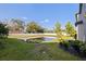 Backyard view overlooking the serene pond surrounded by lush greenery and a pristine white fence at 6542 95Th N Pl, Pinellas Park, FL 33782