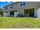 Image showcasing the backyard with a screened patio, lush lawn, and privacy fence at 6745 Citrus Creek Ln, Tampa, FL 33625