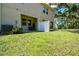 View of the backyard with a covered patio seating area, lush lawn and privacy fence at 6745 Citrus Creek Ln, Tampa, FL 33625