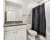 Bathroom features granite countertop vanity, white cabinets, and shower with black shower curtain at 6745 Citrus Creek Ln, Tampa, FL 33625