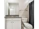 Bathroom features granite countertop vanity, white cabinets, and shower with black shower curtain at 6745 Citrus Creek Ln, Tampa, FL 33625