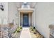 Charming entrance with a blue front door, stone accents, and manicured landscaping at 6745 Citrus Creek Ln, Tampa, FL 33625