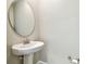 Clean powder room features a pedestal sink, round mirror, and contemporary fixtures with fresh paint at 6745 Citrus Creek Ln, Tampa, FL 33625
