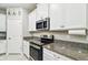Kitchen with stainless steel appliances, granite countertops, and white cabinets at 6745 Citrus Creek Ln, Tampa, FL 33625